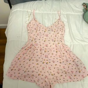 a pink romper with pink and orange flower designs